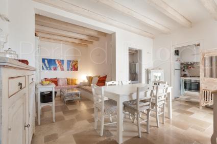 Il soggiorno della Prima Casetta, con sala pranzo e angolo relax con canapè in muratura