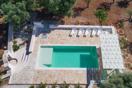 La bellissima piscina con solarium dei Trulli Ion ripresa dal drone di Perle di Puglia