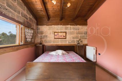 La camera matrimoniale rosa con pietre a vista